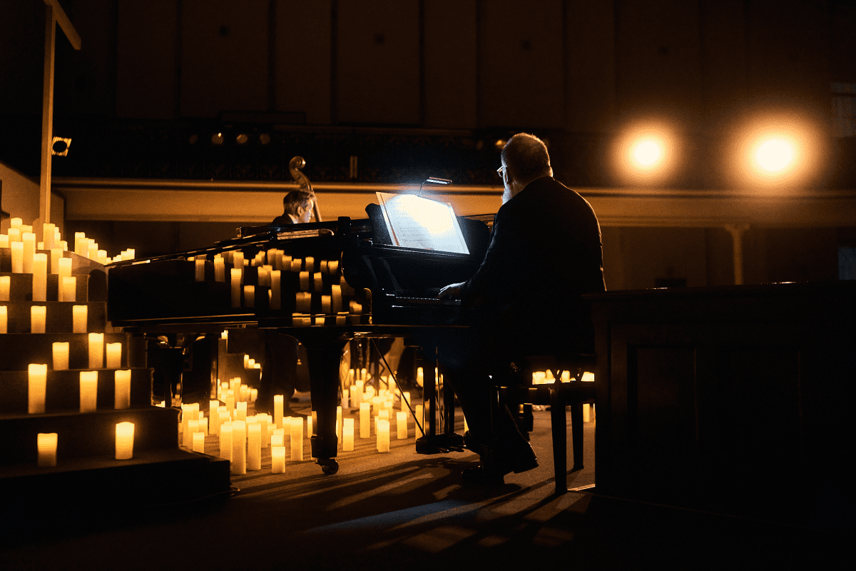 Pianist performs surrounded by candles