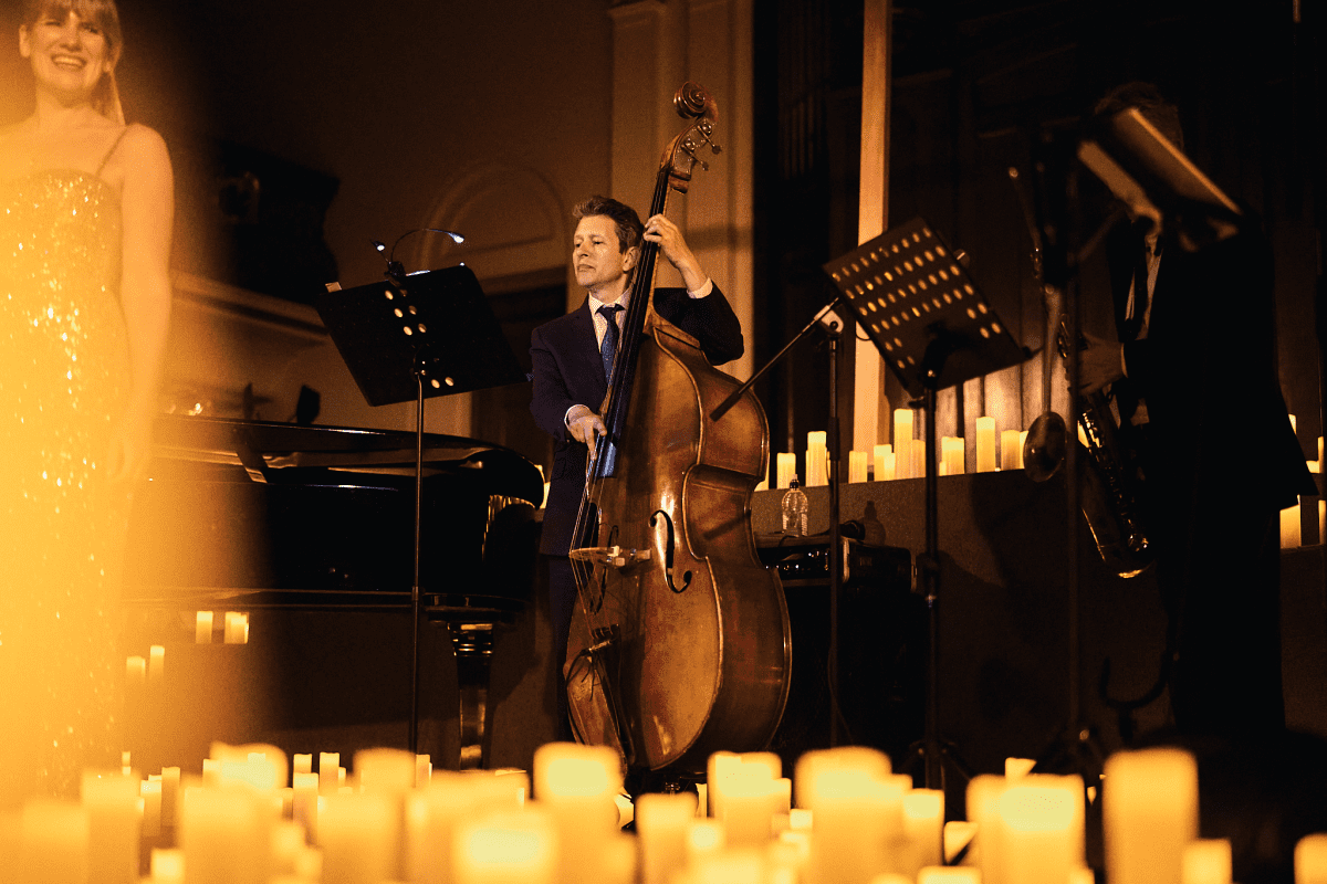 Cello player performs surrounded by candles
