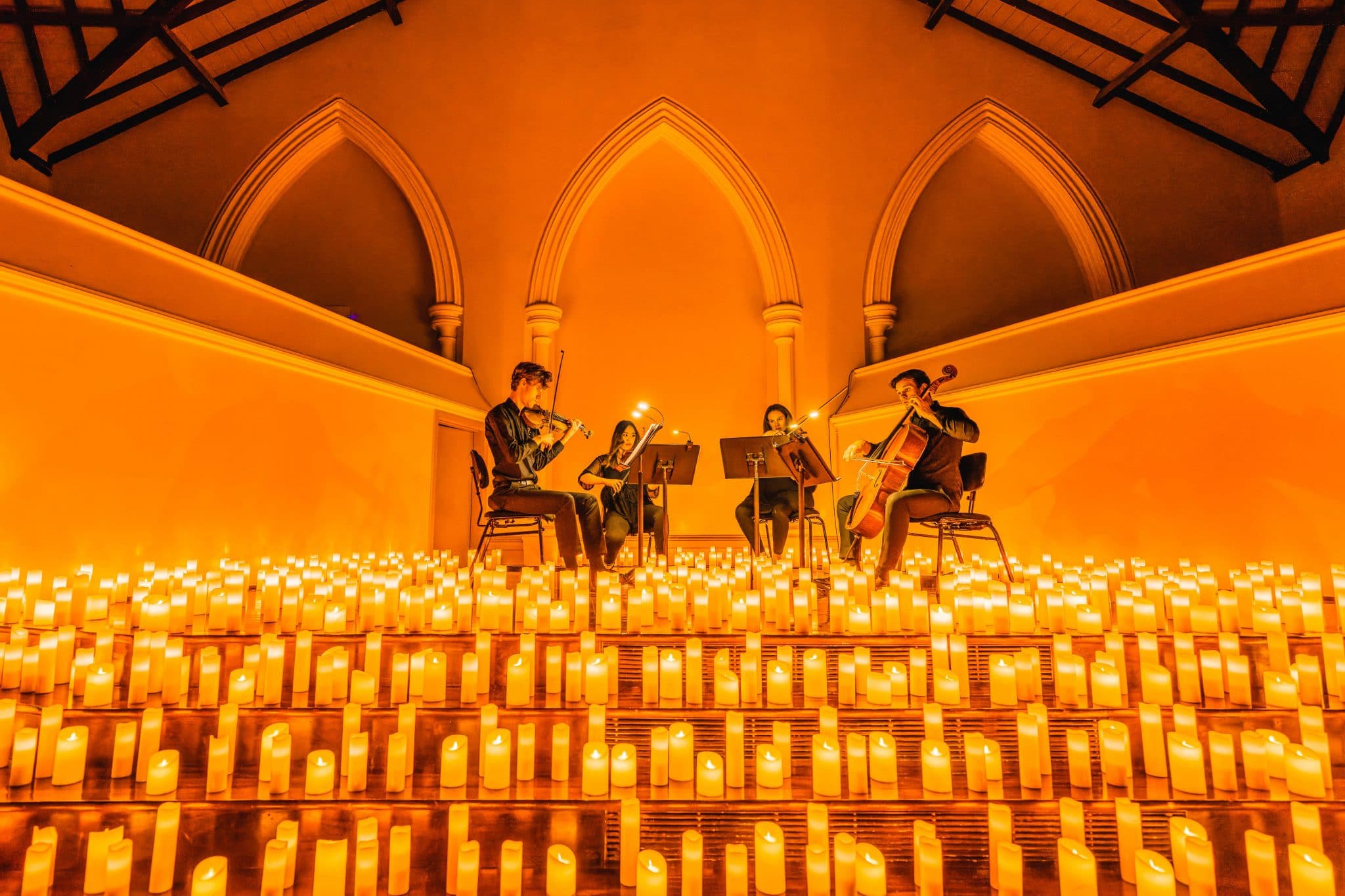 string quartet on stage with hundreds of candles