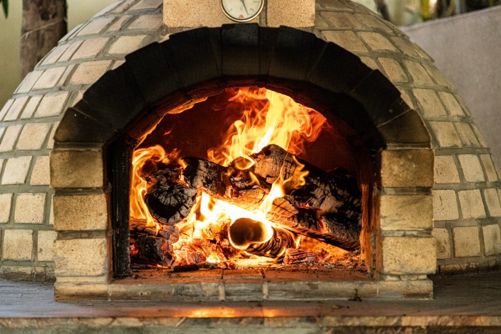 a woodfire oven viewed from the front with fire burning inside