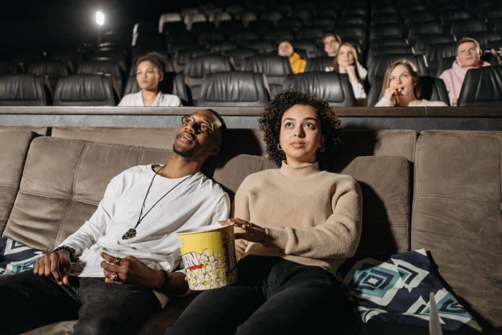 People watching a film at the cinema while eating popcorn